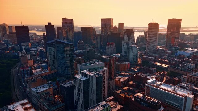 Moving slowly over modern city downtown. Skyline of Boston, Massachusetts, USA against sunset sky.
