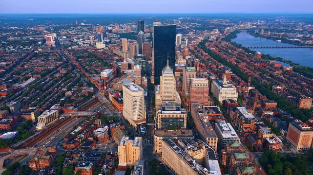 Picturesque panorama of modern lively cityscape. Descend over the green neighborhood of Boston, Massachusetts, USA at sunset.