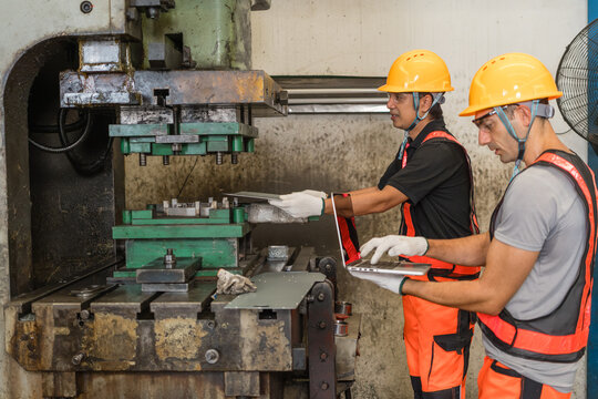 Engineer and technician comparing sheet metal part to punch press die together