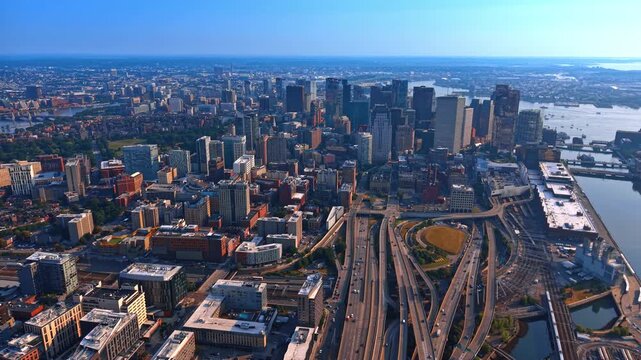 Intertwining highways in the cityscape of modern Boston, Massachusetts, USA. Vast panorama of the city at sunset from drone.