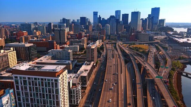 Cars move by the highways and trestles in the cityscape of Boston, Massachusetts, USA. Approaching the high-rise cluster of buildings in the downtown skyline.