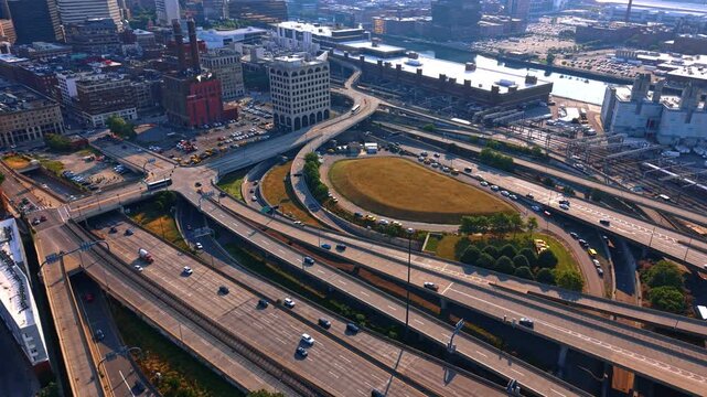Transport moves quickly by the roads and trestles at sunset time. Lively cityscape of Boston, Massachusetts, USA from drone.