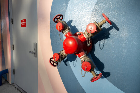 Title: Fire department connection FDC valve mounted on blue mural wall
