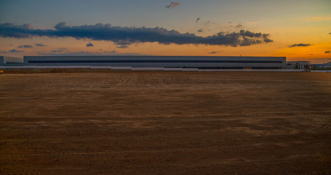 Empty land plot prepared for industrial construction and warehouse development at sunset.Large land area for industrial factory project with sunset sky background and copy space.