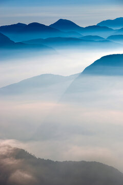 Mountain peaks emerge above a sea of morning fog in an alpine destination landscape, evoking serene exploration, Julian Alps Natural Park,Alba Valley,Friuli Venezia Giulia,Italy.