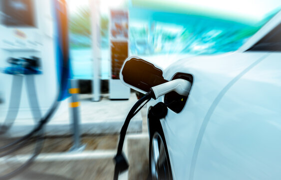 Electric vehicle charging at a fast charging station. Sustainable transportation, renewable energy infrastructure, battery technology and future of clean mobility. Zero emission transportation.