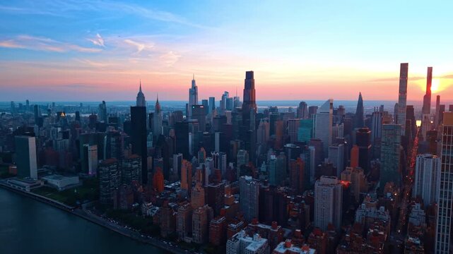 Heading to the dense urban landscape of modern New York City. Drone flight over metropolis at sunset time.