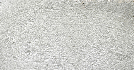 Obraz premium Horizontal close up of a concrete barrier block surface with a rough flat uneven light gray concrete texture and tough marks 