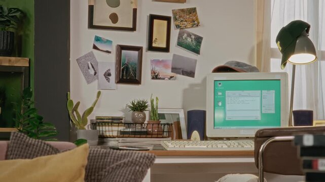 Retro computer setup being revealed by panning camera with CRT monitor displaying vintage operating system. Clip is ideal for retro technology documentaries or nineties nostalgia marketing