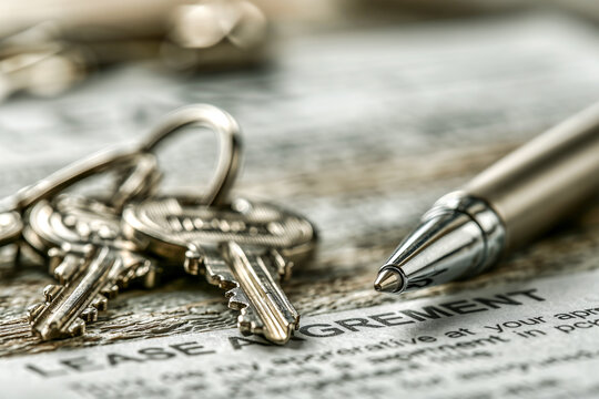 Close up of apartment or house keys, pen and lease agreement, signing a contract for a new home, real estate law