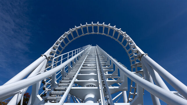 Metal roller coaster arch structure climbing up into deep blue sky.