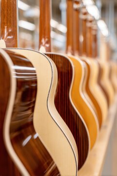 Row of acoustic guitar bodies in workshop with polished wood finish for music store display and instrument background
