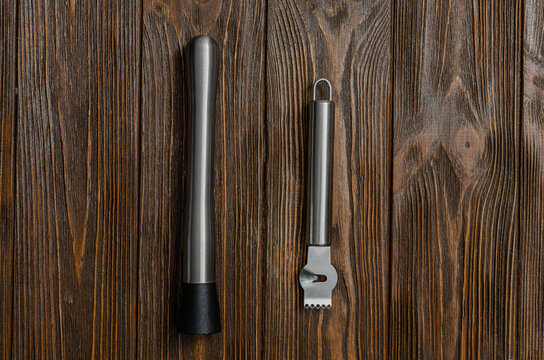 Stainless Steel Cocktail Muddler and Citrus Zester on Dark Wooden Surface