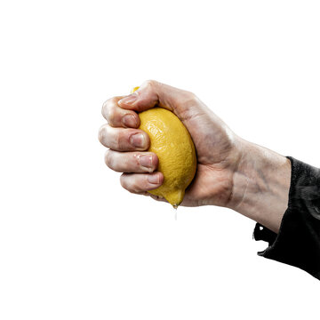 Hand squeezing a fresh yellow lemon isolated on a transparent background