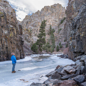 senior male hiker in a canyon of mountain river in winter scenery - Poudre River at Little Narrow above Fort Collins, Colorado