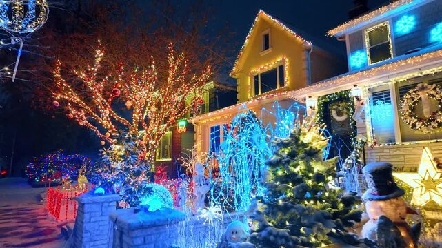 New York City homes with colorful Christmas yard displays. Red, blue and warm white lights cover bare trees, wreaths and snowy facades.