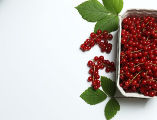 Redcurrant berries with green leaves on a white background. © Pixora ST 