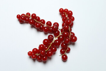 Redcurrant berries with green leaves on a white background. © Pixora ST 