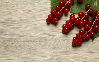 Redcurrant berries with green leaves on a white background. © Pixora ST 