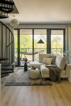 Modern Living Room with Spiral Staircase and Green Balcony View