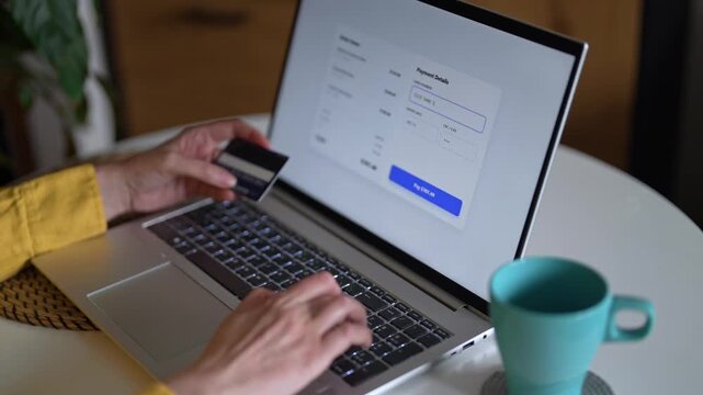Woman paying online using credit card and laptop at home.