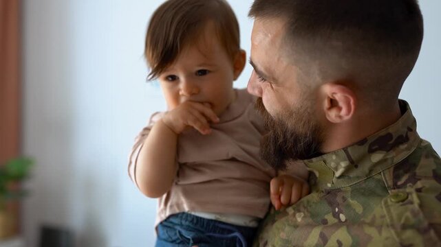 Male soldier in military uniform returning home to family - Father hugging baby son - Homecoming, happiness and love concept	