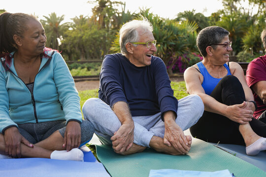 Multiracial senior people having fun together during yoga class at city park - Elderly group of friends, active lifestyle and sport concept