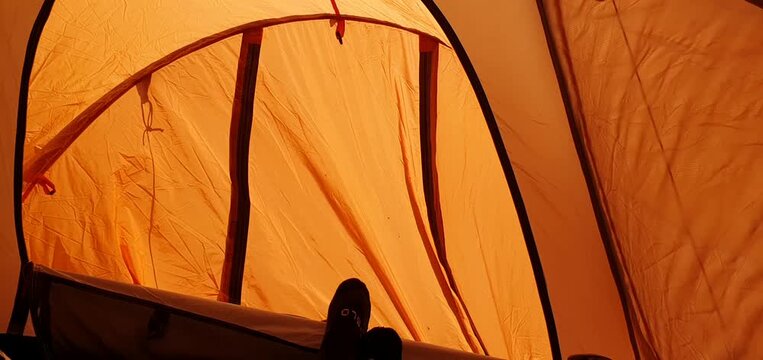 Inside View of an Orange Camping Tent Facing the Wind