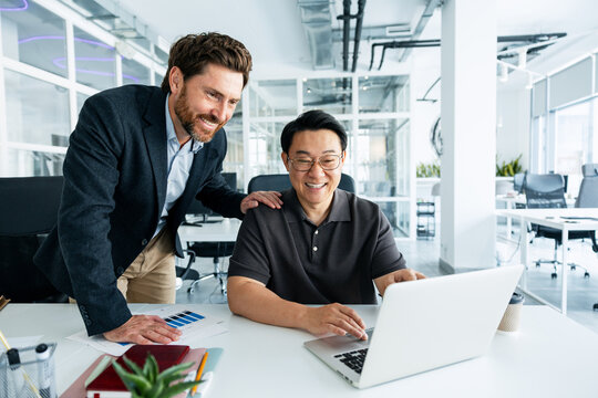 Business people collaborating on laptop in modern office