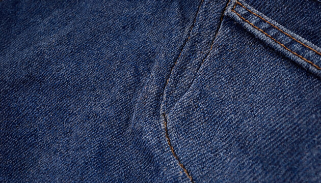 Close up view of dark blue denim jeans fabric texture showing pocket stitching detail with material design material stitching clothing close-up background textured