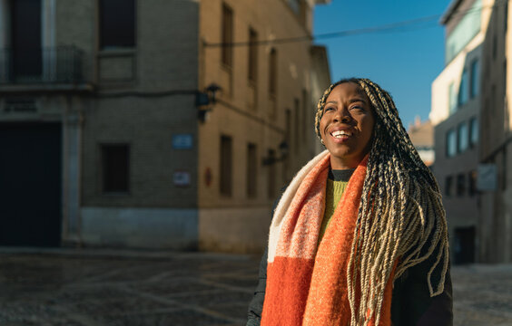 African american woman smiling outdoor enjoying sunlight in city