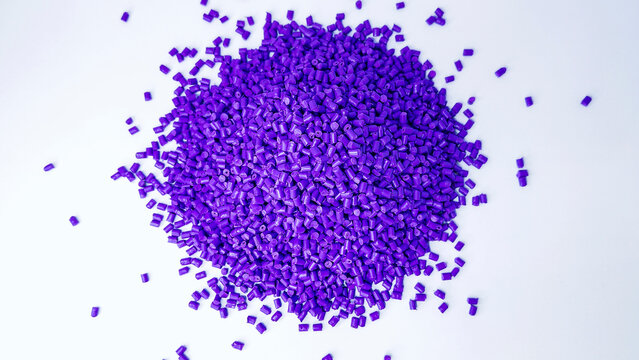 Purple masterbatch granules, cold cutting type, polymer carries color pigment poured into a white background medium, suitable for product catalog design of industrial plastic company profiles