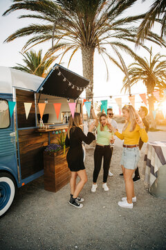 Young ladies drinking wine during beach party