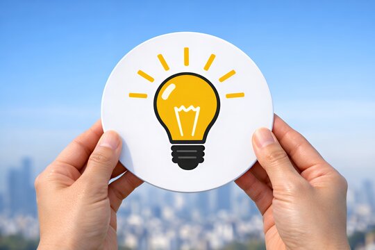 ひらめき電球を両手で支える都市と青空のアイデア