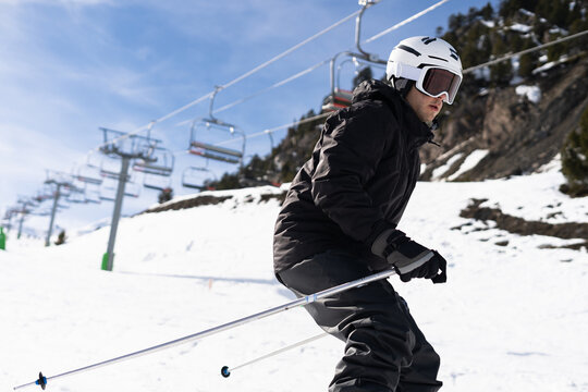 Skier Enjoying Bright Day on Snowy Slope During Winter Season