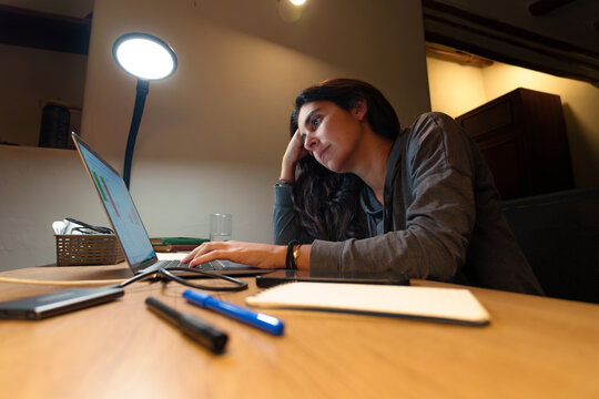 Tired Woman Working Late on Laptop at Night at Home