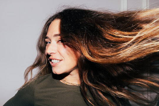 Woman with flowing hair and a confident smile