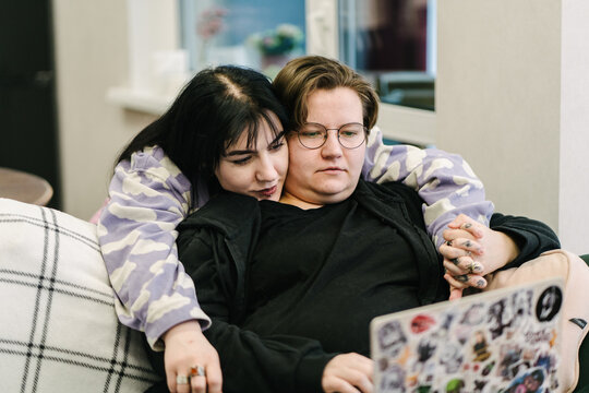 Two girlfriends are working at home on a laptop.