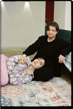 Two friends are relaxing in the living room.
