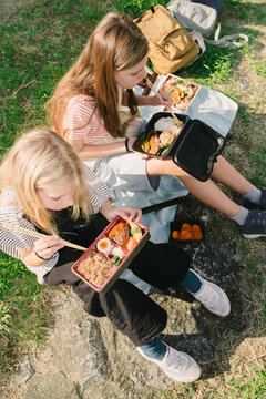 Girls eating bento boxes outdoors