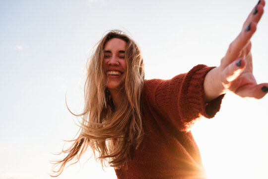 A happy young woman dancing at sunset. Copy space, summer