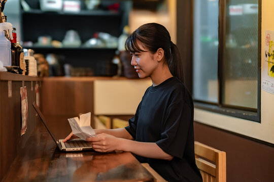レシートを見てパソコンに入力する女性