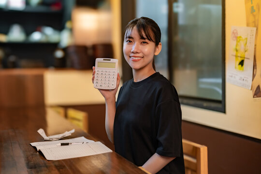 電卓を見せる女性