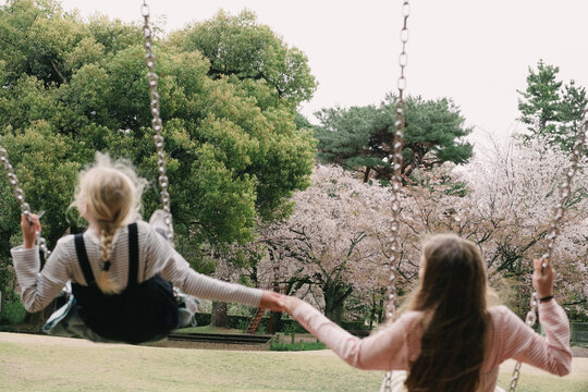 Two girl swinging in the park
