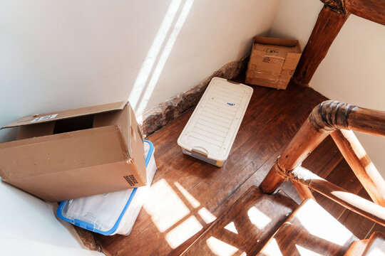 Cardboard Box and Plastic Containers Stacked on Moving Day