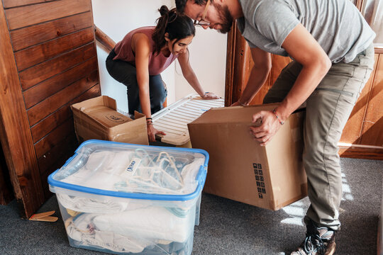 Couple Carrying Boxes While Moving In 