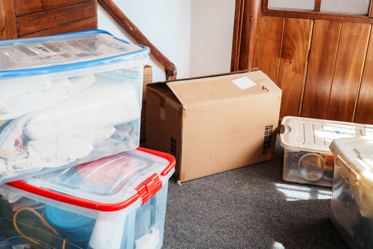 Cardboard Box and Plastic Containers Stacked on Moving Day