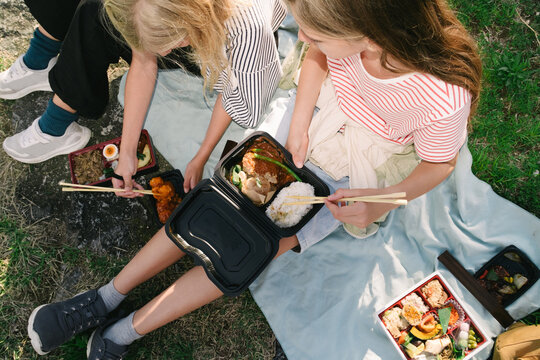 Kids eating bento boxes outdoors