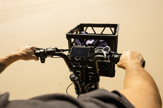 POV UGC riding e bike or electric bike on sandy beach  with bike crate