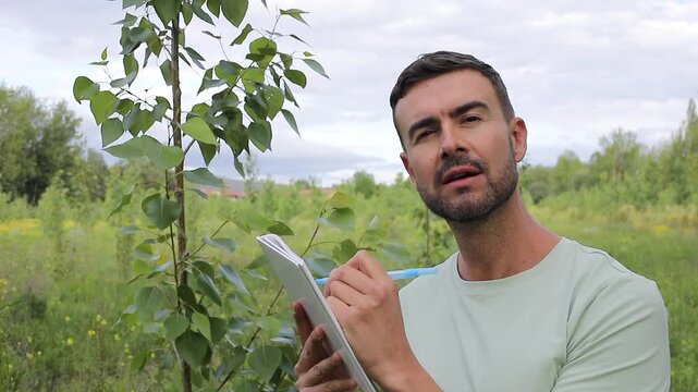 Inspector Using a Notebook To Write the Evaluation of a Poplar Tree Health